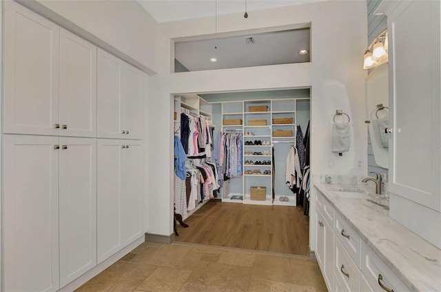 walk in closet featuring sink and light hardwood / wood-style floors