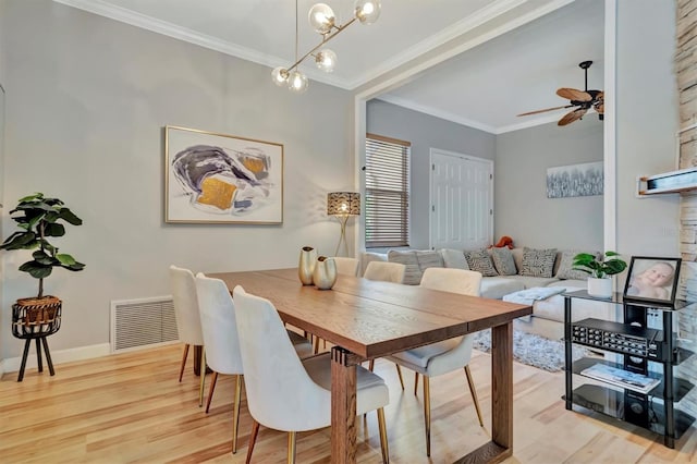 dining area with light wood-type flooring, ceiling fan with notable chandelier, and crown molding