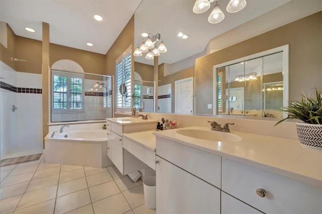 bathroom with a notable chandelier, double sink vanity, independent shower and bath, and tile patterned flooring