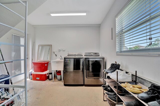 clothes washing area featuring sink and washing machine and dryer