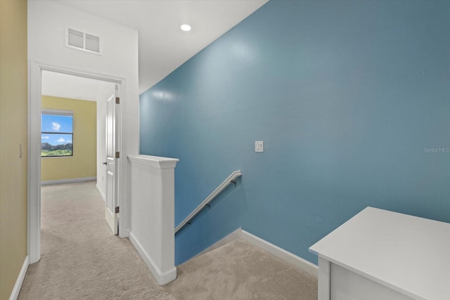 hallway featuring light colored carpet