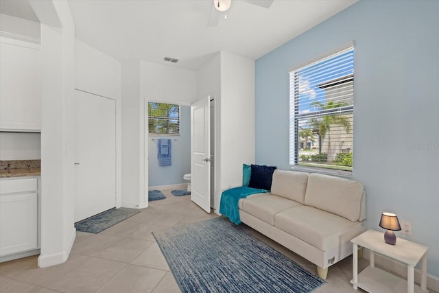 tiled living room with ceiling fan