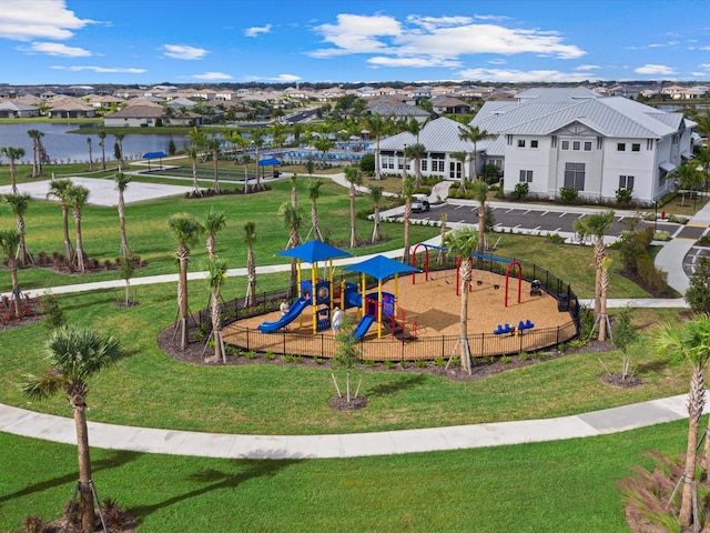 view of playground with a water view and a lawn