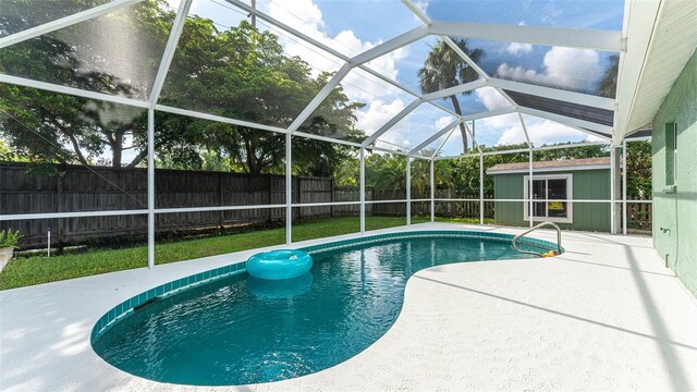 view of pool featuring a patio area, an outbuilding, and a lanai