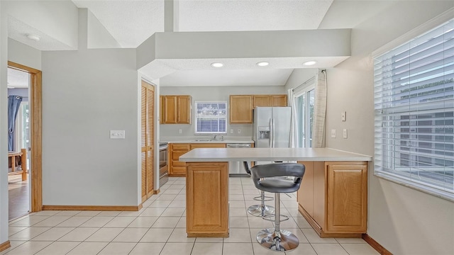 kitchen featuring stainless steel appliances, sink, a kitchen island, vaulted ceiling, and light tile patterned flooring