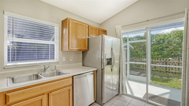 kitchen with light tile patterned flooring, appliances with stainless steel finishes, sink, and lofted ceiling