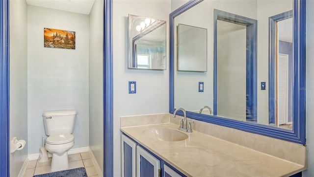 bathroom featuring toilet, a textured ceiling, tile patterned floors, and vanity