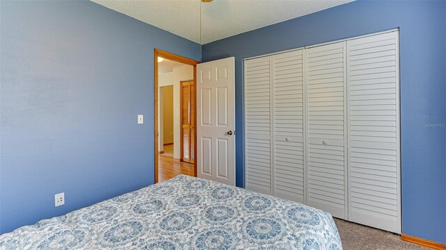 bedroom featuring a closet, a textured ceiling, and carpet floors