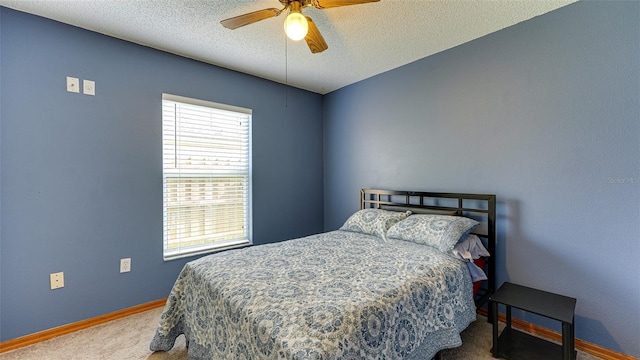 bedroom featuring ceiling fan, a textured ceiling, and carpet floors