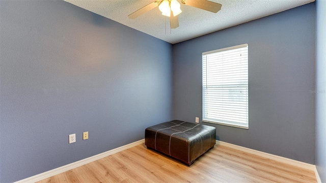 sitting room with light wood-type flooring, plenty of natural light, and ceiling fan