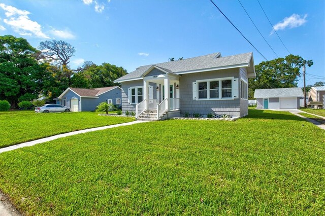 bungalow-style home with an outbuilding, a front lawn, and a garage