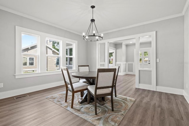 dining area featuring a chandelier, hardwood / wood-style flooring, and ornamental molding