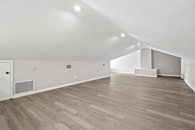 bonus room with hardwood / wood-style floors and lofted ceiling