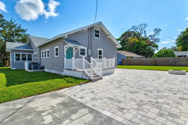 rear view of house featuring cooling unit, a patio area, and a lawn