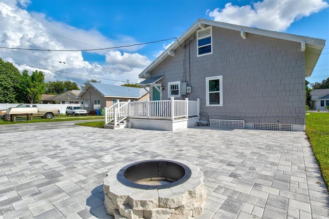 back of property featuring an outdoor fire pit and a patio