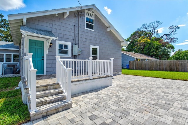 rear view of house featuring a patio area, central AC unit, and a yard