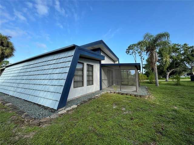 view of property exterior with a sunroom and a lawn