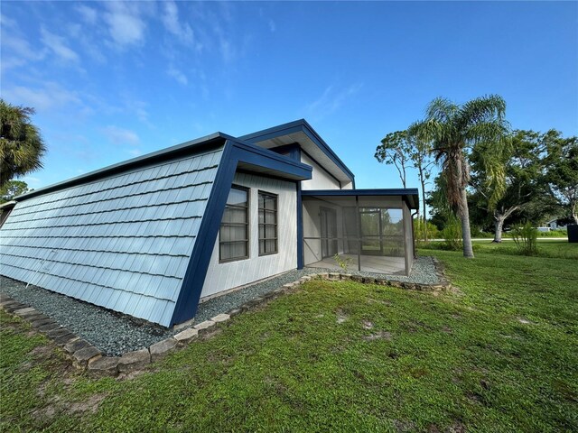 view of home's exterior with a sunroom and a yard