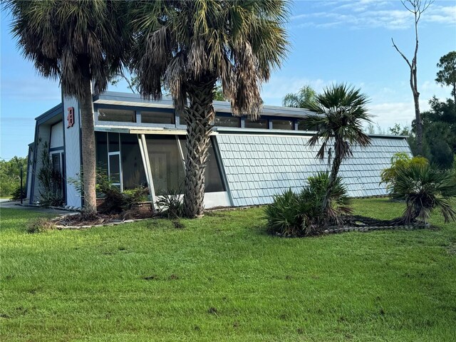 rear view of house with a yard and a sunroom