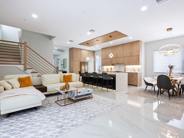 tiled living room featuring a notable chandelier