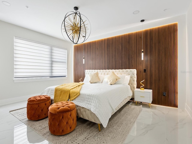 bedroom featuring marble finish floor, baseboards, and wood walls