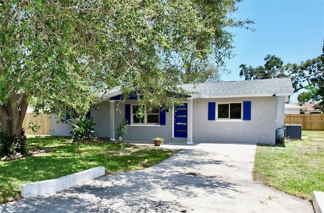 ranch-style home with stucco siding, fence, central AC unit, and a front yard