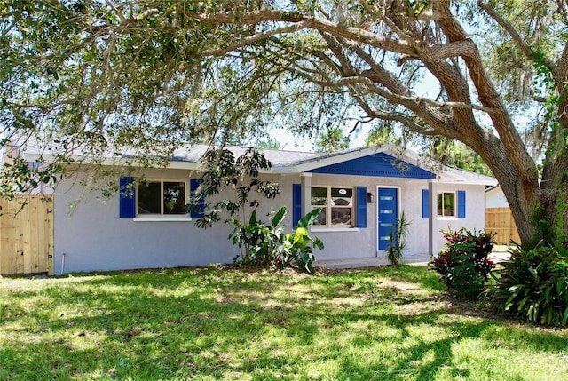 single story home with stucco siding, fence, and a front lawn