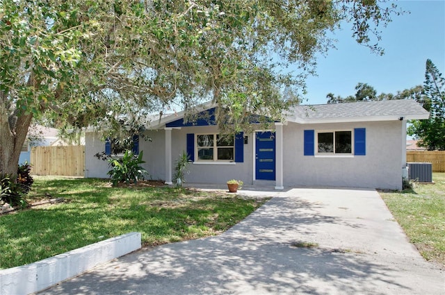 ranch-style home with central AC unit and a front yard