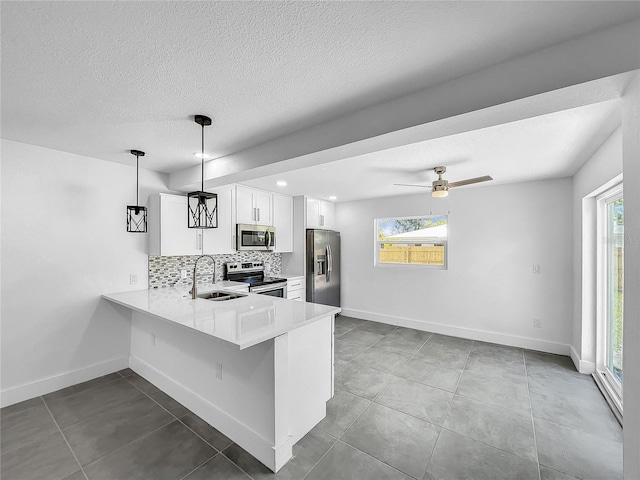 kitchen with decorative light fixtures, white cabinetry, appliances with stainless steel finishes, and light tile patterned floors