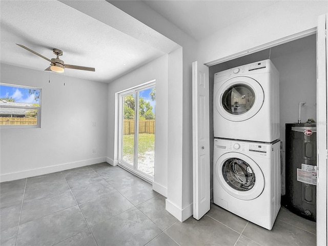 laundry area with ceiling fan, light tile patterned flooring, stacked washer and dryer, and water heater