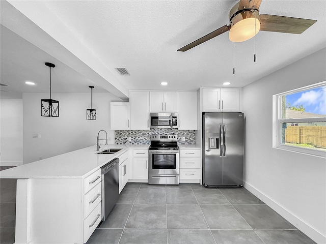 kitchen with stainless steel appliances, sink, white cabinets, light tile patterned floors, and ceiling fan