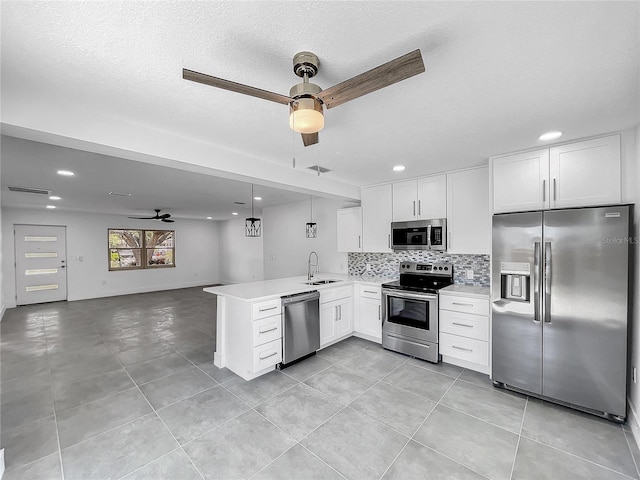 kitchen with white cabinetry, decorative light fixtures, ceiling fan, stainless steel appliances, and kitchen peninsula