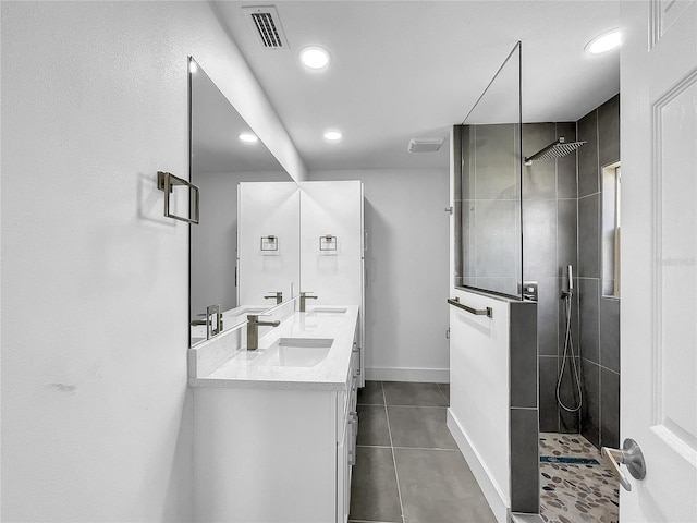 bathroom with tiled shower, vanity, and tile patterned floors