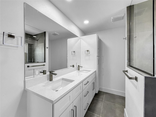 bathroom with tile patterned floors, a tile shower, and vanity