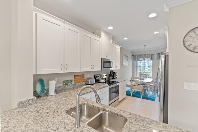 kitchen featuring stainless steel appliances, decorative light fixtures, white cabinetry, ornamental molding, and sink