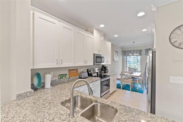 kitchen with light stone counters, stainless steel appliances, ornamental molding, white cabinetry, and a sink