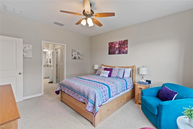 bedroom with light colored carpet, visible vents, ceiling fan, and ensuite bathroom