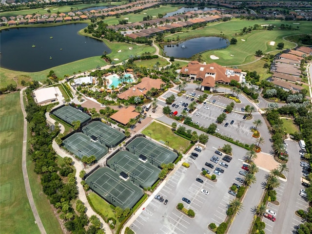 drone / aerial view with view of golf course and a water view