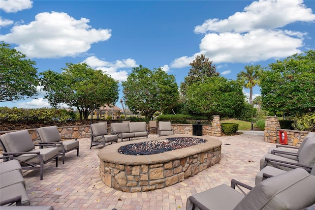 view of patio with an outdoor living space with a fire pit