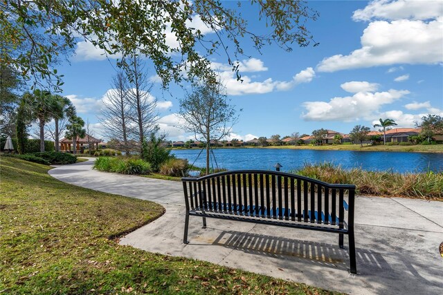 view of home's community with a lawn and a water view