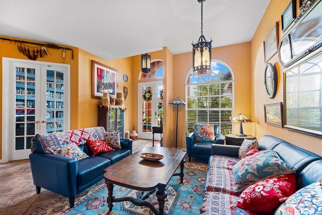 living room with french doors, tile patterned floors, and a notable chandelier