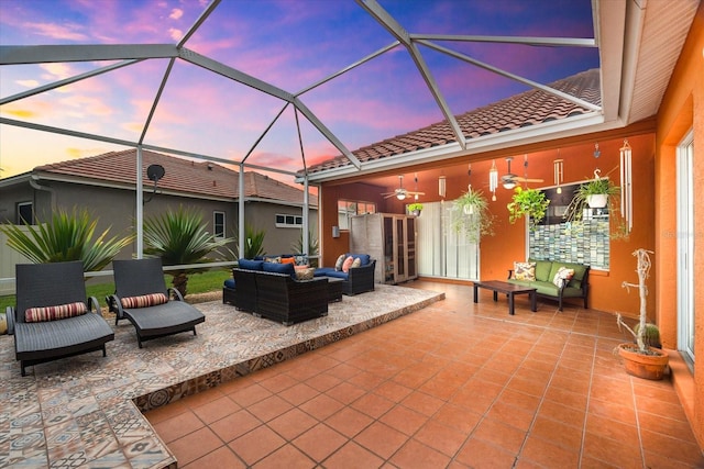 patio terrace at dusk featuring an outdoor living space and glass enclosure