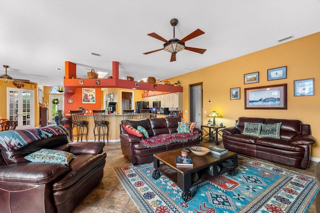 tiled living room featuring ceiling fan, french doors, and lofted ceiling