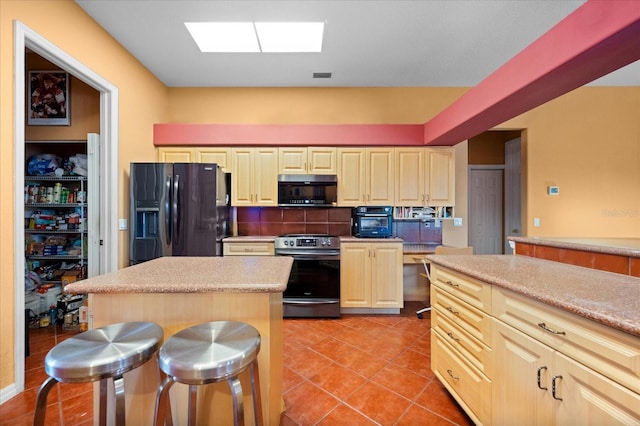 kitchen with range with electric cooktop, a center island, black refrigerator with ice dispenser, backsplash, and a breakfast bar area