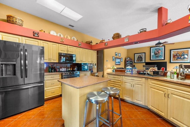 kitchen with a center island, stainless steel appliances, a kitchen breakfast bar, kitchen peninsula, and light tile patterned floors