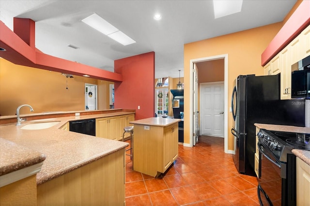 kitchen with black appliances, sink, a center island, a breakfast bar area, and light tile patterned flooring