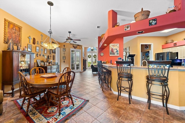 dining space with tile patterned flooring and ceiling fan with notable chandelier