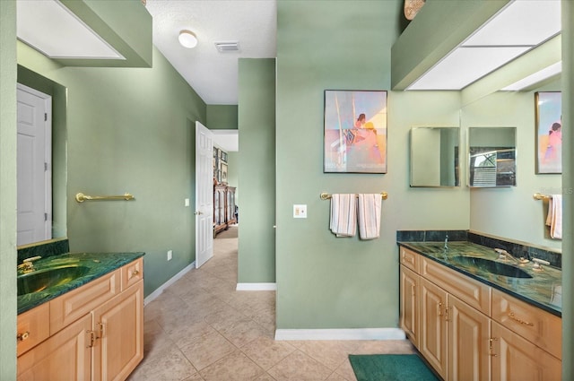 bathroom featuring tile patterned flooring, vanity, and a textured ceiling