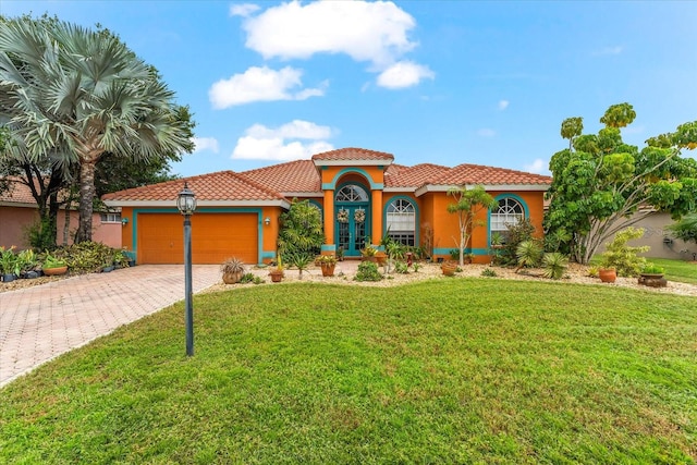 mediterranean / spanish-style home featuring a garage and a front yard