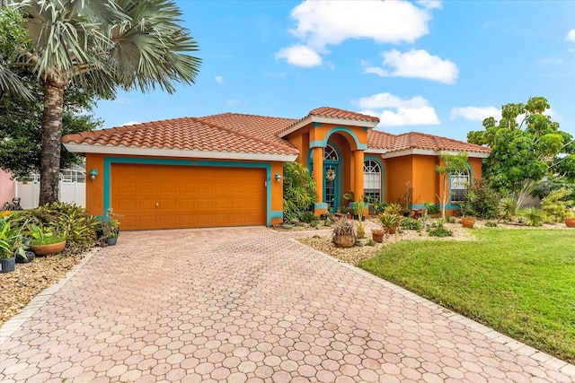 mediterranean / spanish-style house with a front lawn and a garage